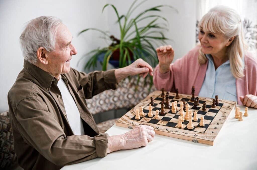 A senior couple engaged in a chess game at home