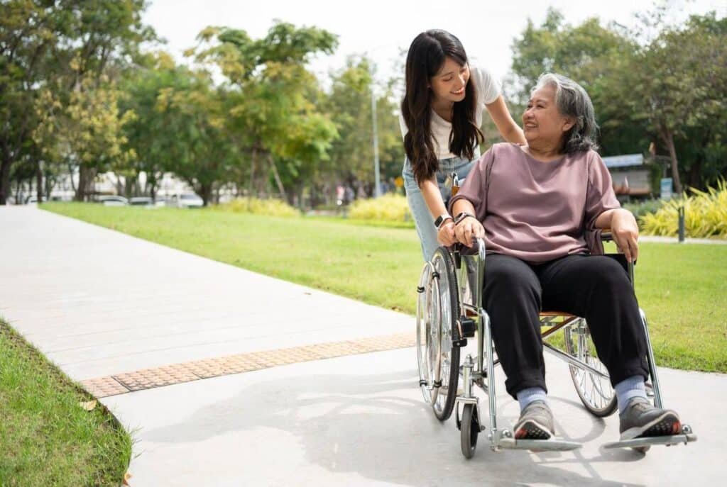 A woman in a wheelchair assists an elderly woman