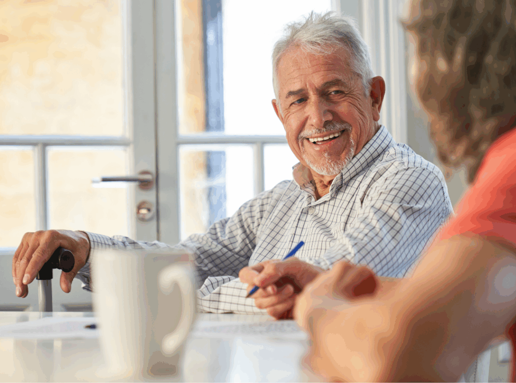 A man and woman smiling together at a table, enjoying each other's company.